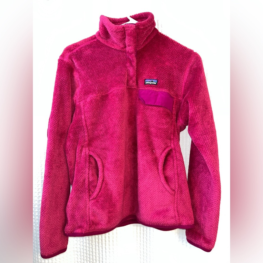 Dark pink fleece pullover by Patagonia with a kangaroo pocket.